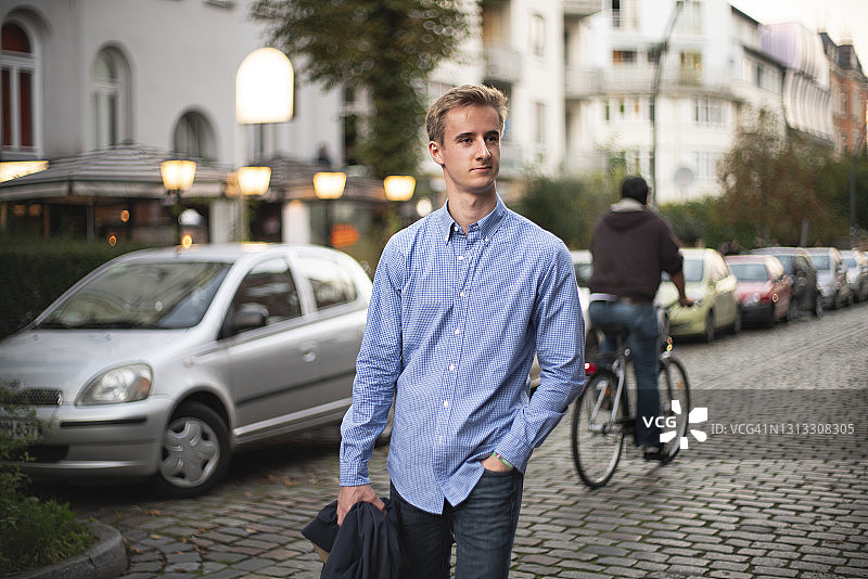 穿着蓝色衬衫的年轻男人走在汉堡尚茨的街道上图片素材