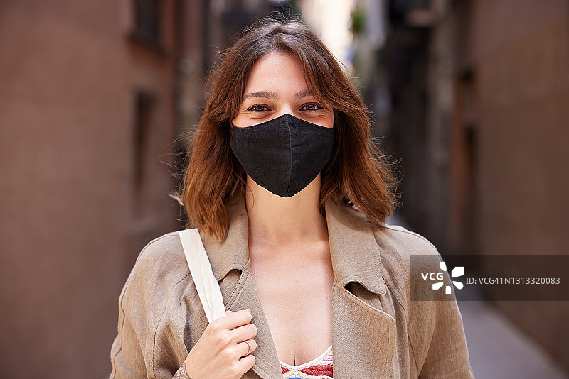 戴防护口罩微笑的年轻女人图片素材