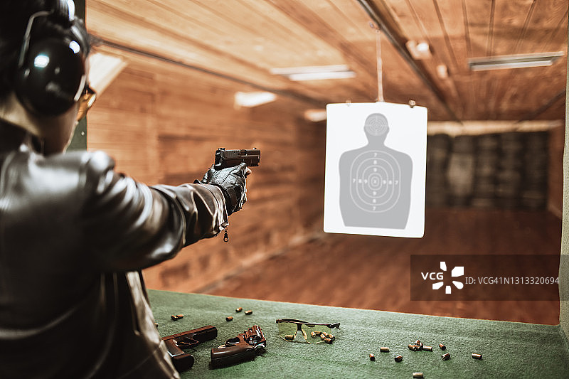 女性在射击场测试喜爱的枪支图片素材