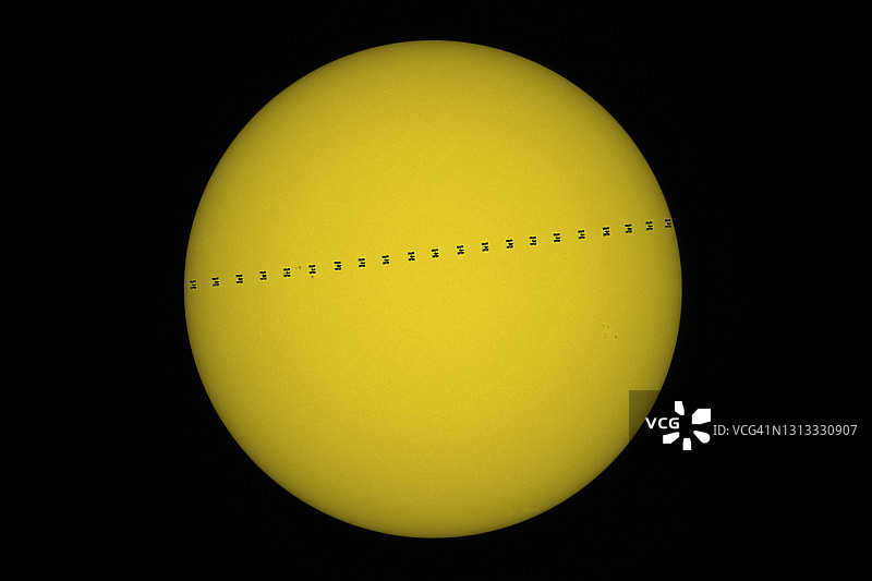 国际空间站飞越太阳圆盘的壮观景象图片素材