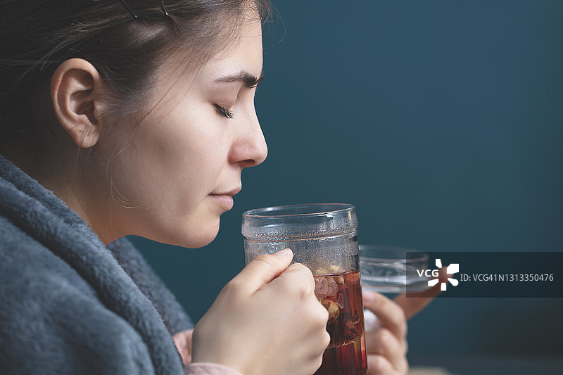 裹着毯子喝热茶的女人图片素材