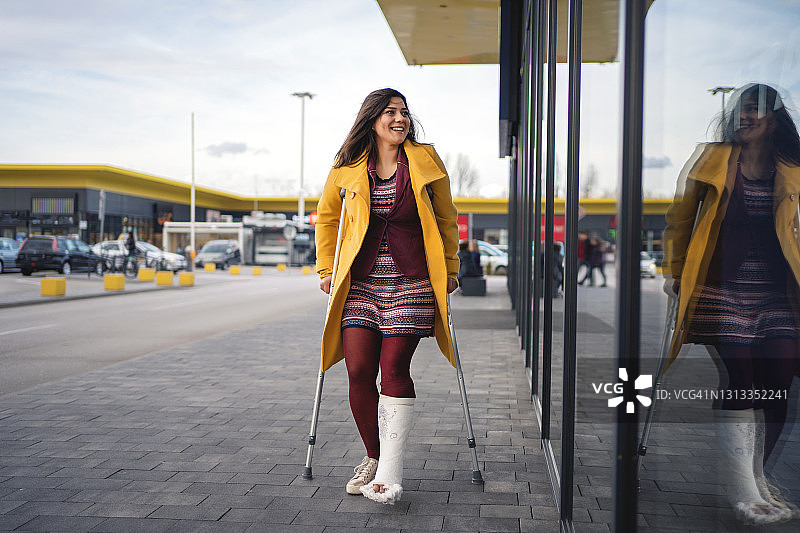脚上打着石膏走路的女人图片素材
