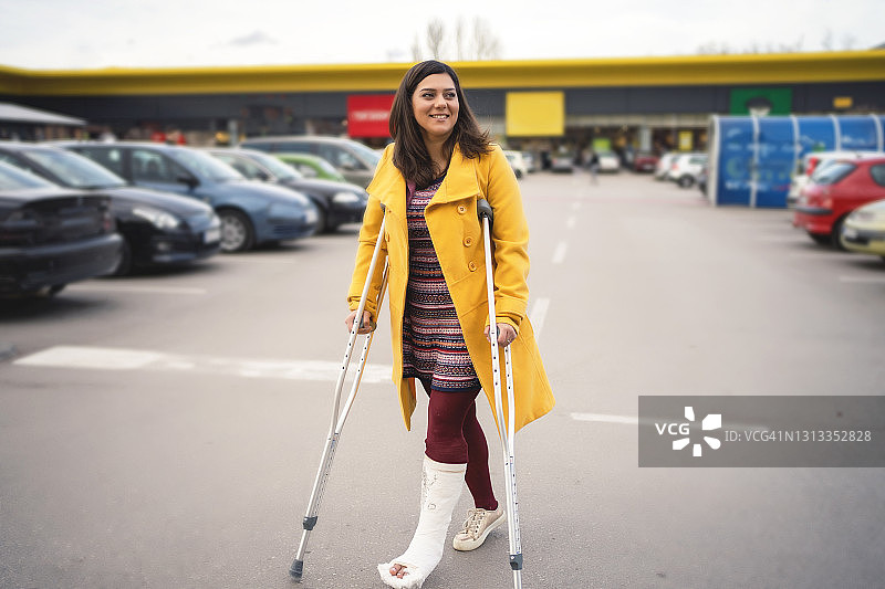 脚上打着石膏走路的女人图片素材