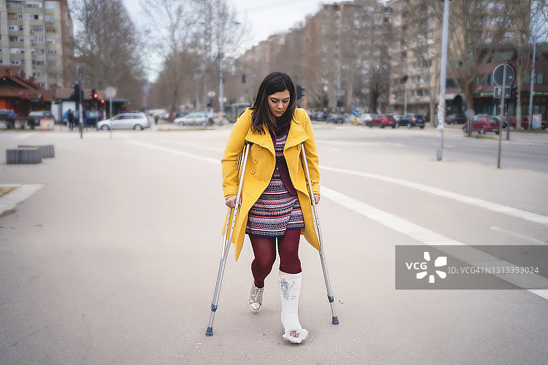 脚上打着石膏走路的女人图片素材