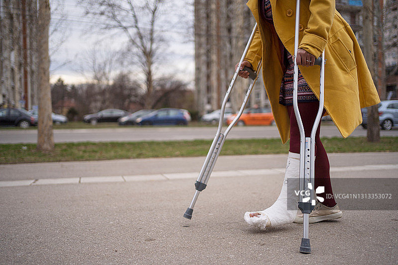 脚上打着石膏走路的女人图片素材