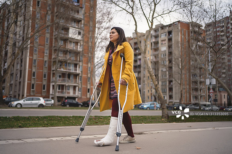 脚上打着石膏走路的女人图片素材