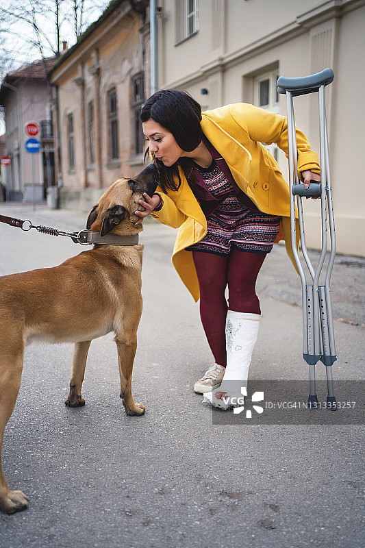 脚上打着石膏的女人与狗图片素材