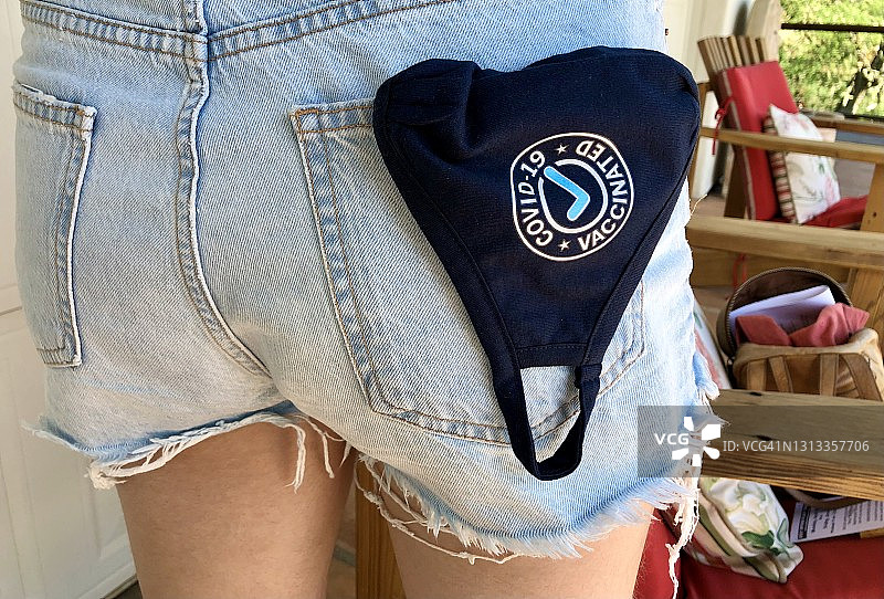 口袋里露出已接种疫苗的口罩图片素材