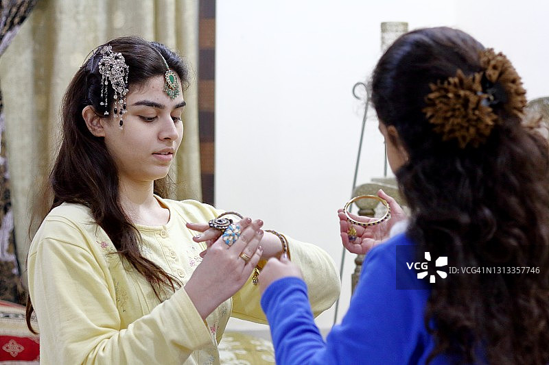 妹妹帮姐姐佩戴手镯图片素材