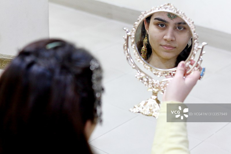 年轻女子在梳妆镜中的面部倒影图片素材