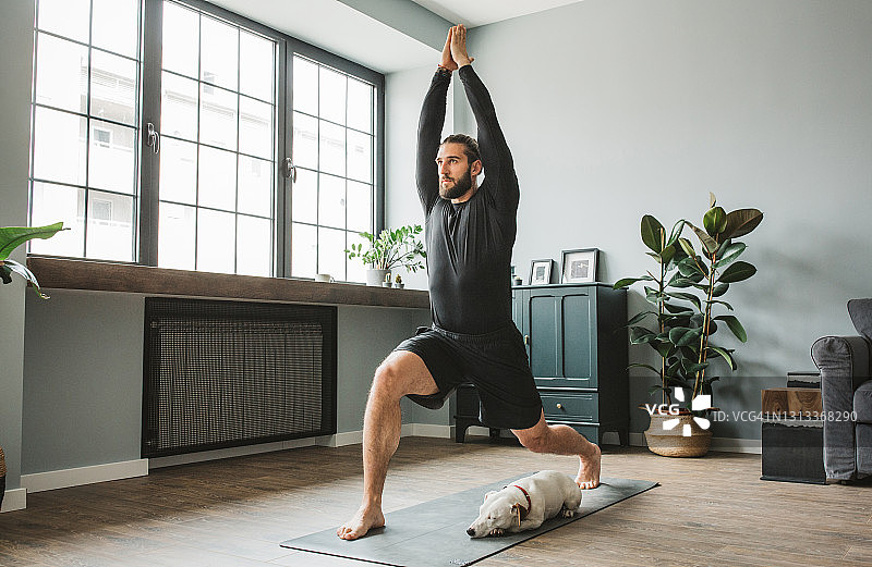 在家练习瑜伽的年轻男人图片素材