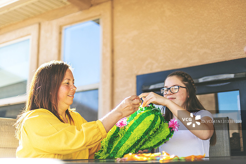 X世代西班牙裔母亲和青春期前女儿准备彩罐照片系列图片素材