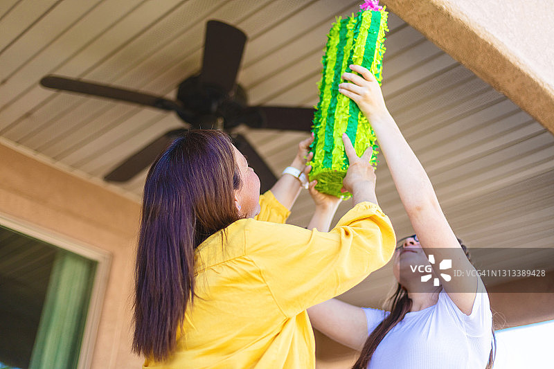 X世代西班牙裔母亲和青春期前女儿准备彩罐照片系列图片素材