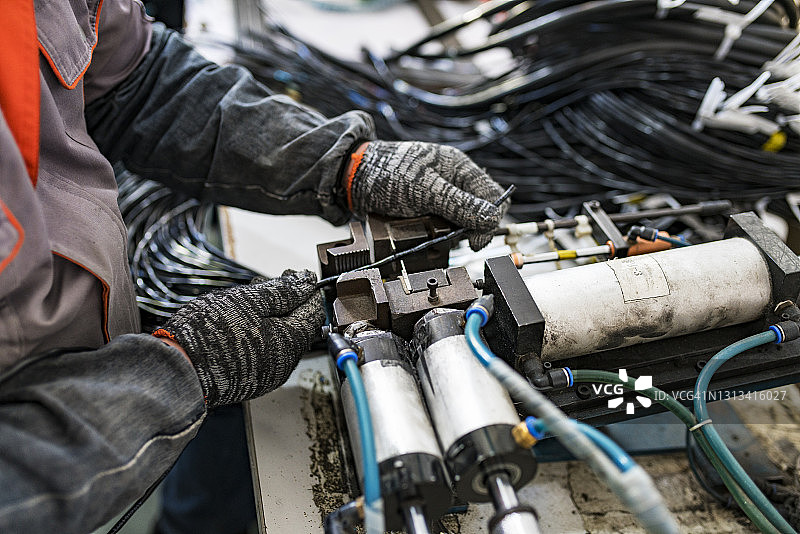 年轻男人在工厂的生产线上工作图片素材