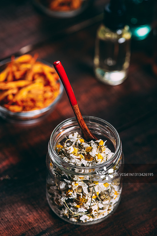 乡村木桌上的干花与精油瓶图片素材