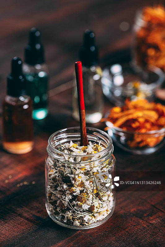 乡村木桌上的干花与精油瓶图片素材