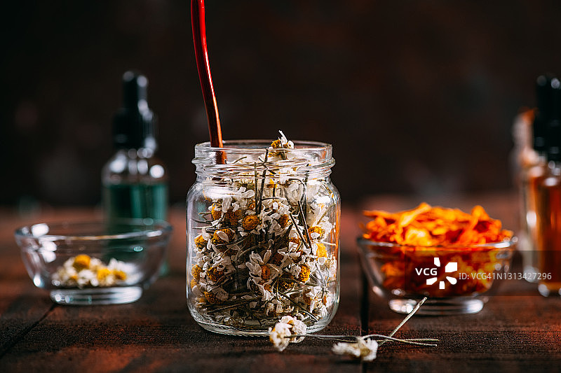 乡村木桌上的干花与精油瓶图片素材