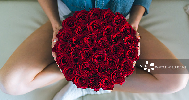 拿着一束鲜花的女人。盒子里的花图片素材