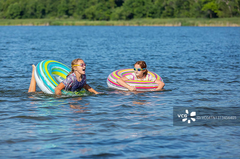 在夏日湖中游泳的两个女孩图片素材