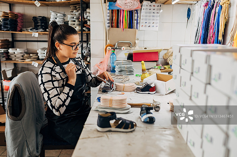 鞋厂女工整理童鞋鞋带，为交货做最后准备图片素材