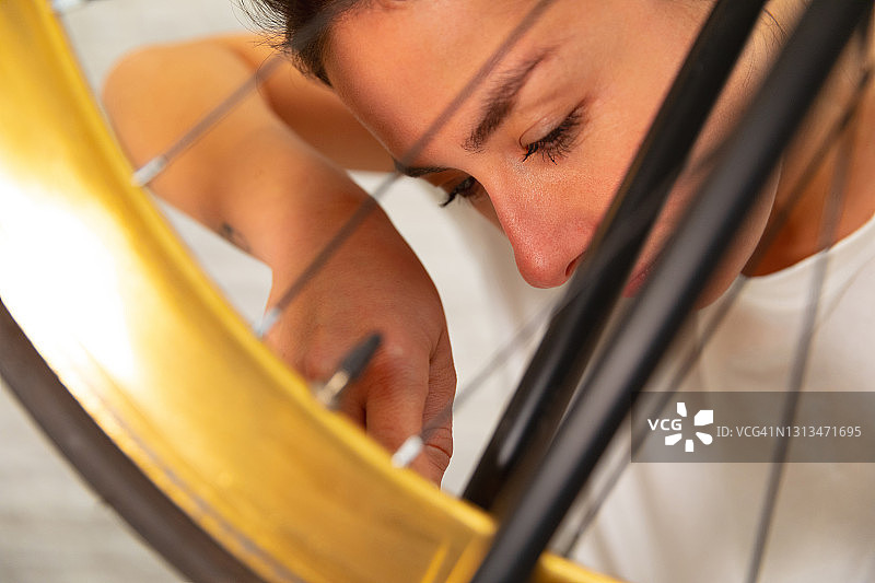 年轻女性修理自行车图片素材