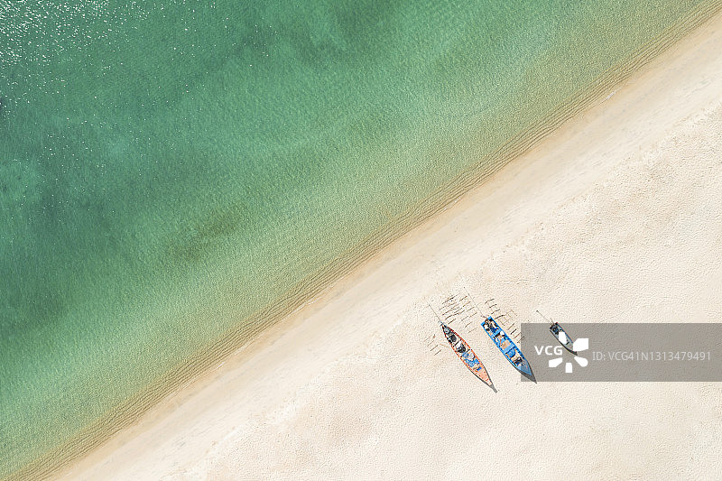 绿松石水域、彩色皮划艇和椰子树的美丽海滩鸟瞰图图片素材