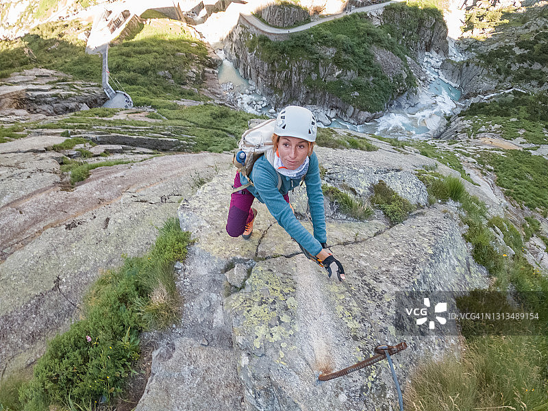 在费拉塔攀岩道上攀登的年轻女性图片素材