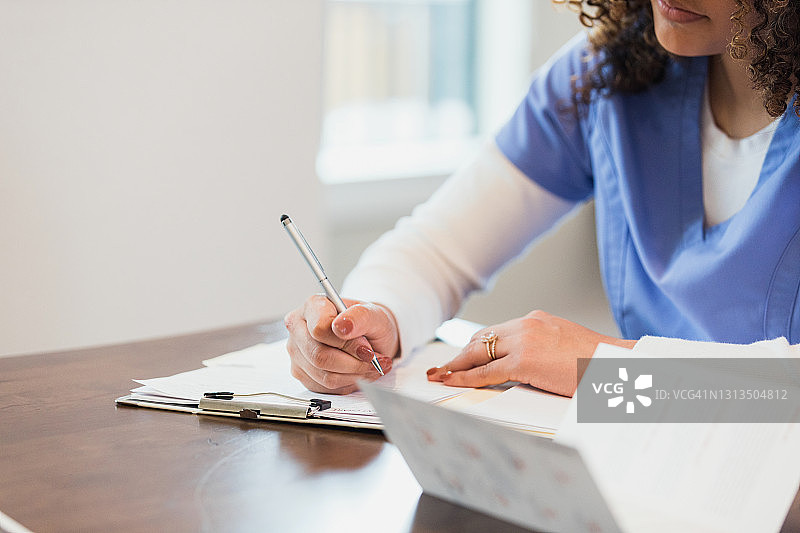 女医生在病人之间处理医疗记录图片素材