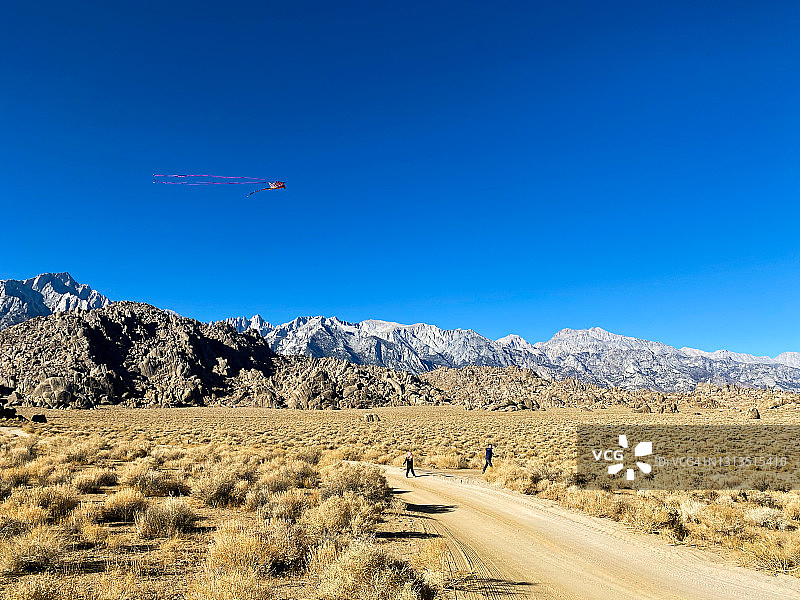 在加利福尼亚州茵 यो县惠特尼山脚下徒步和放风筝的家庭图片素材