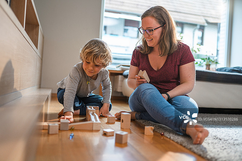 客厅里玩弹珠的可爱白人母子图片素材