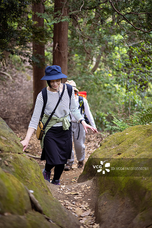 在森林中徒步旅行，走在狭窄小路上的日本女人图片素材