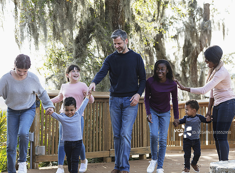 在公园里步行的有五个孩子的混合家庭图片素材