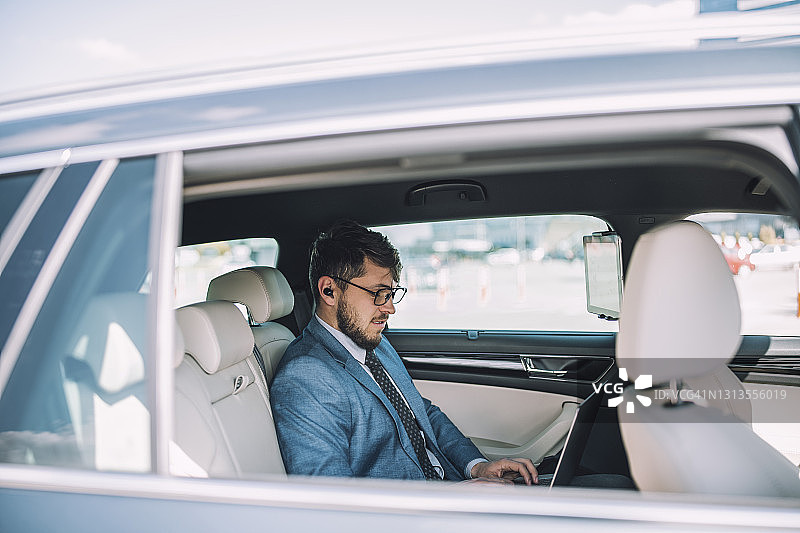 在出差期间使用科技产品的英俊企业家图片素材