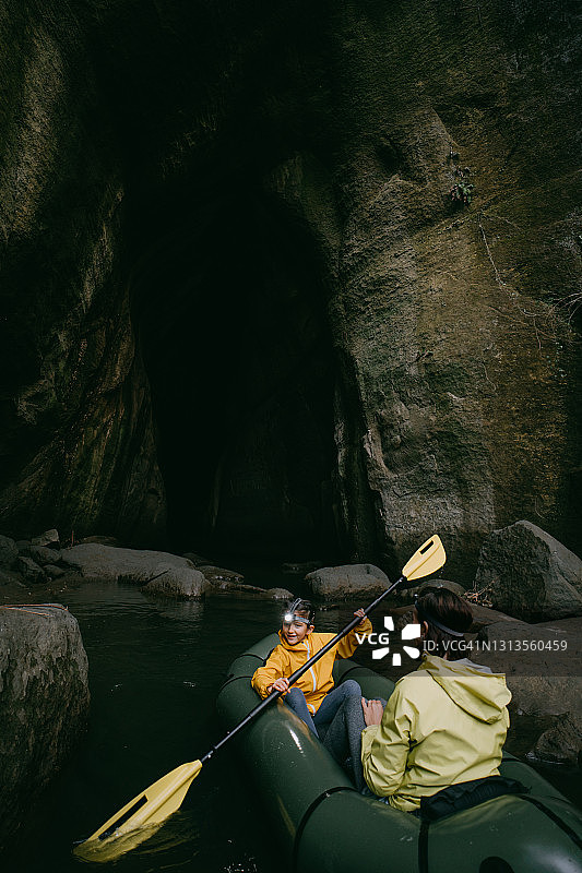 可爱的年轻女孩和母亲在洞穴中划皮划艇图片素材