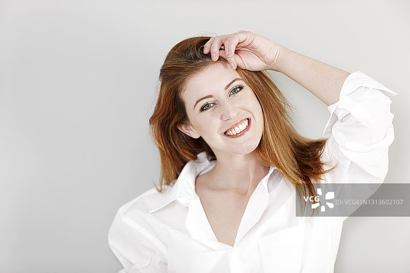 身穿白衬衫的年轻女人，面露喜色。图片素材