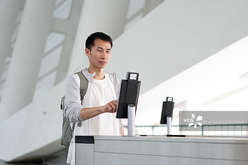 正在使用面部识别机器的亚洲男人图片素材