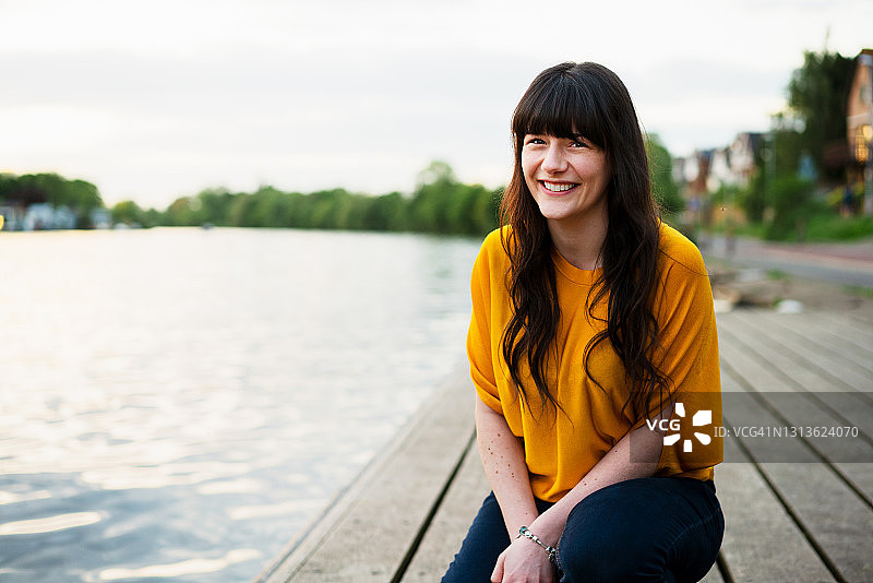 跪着并对着镜头微笑的女人图片素材