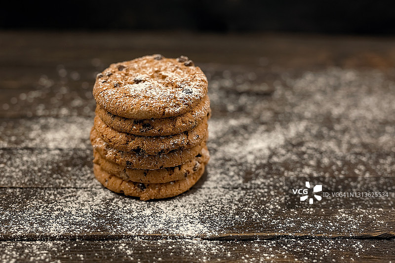 木制背景上垂直堆叠的葡萄干燕麦饼干图片素材