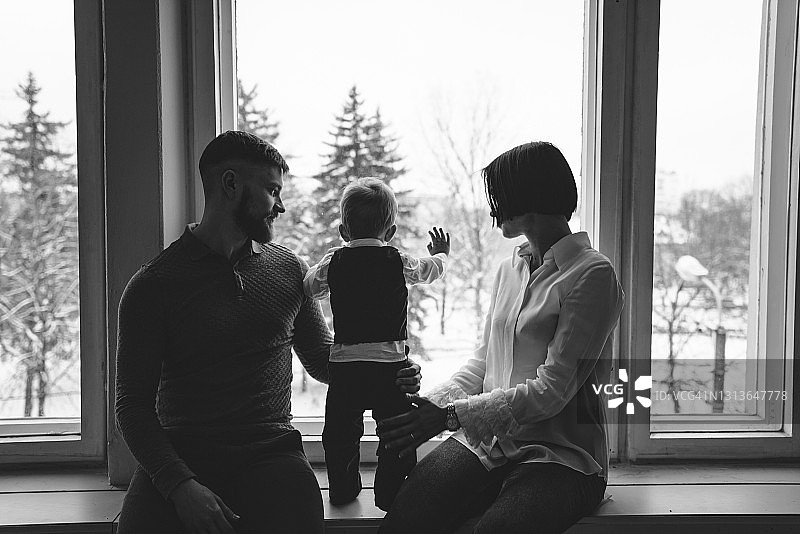 父母和男婴在窗边图片素材
