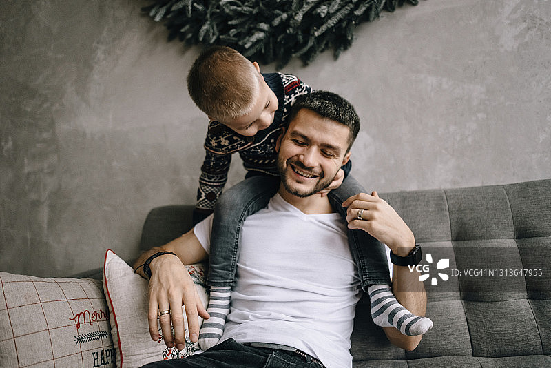 儿子坐在快乐的父亲的肩膀上图片素材