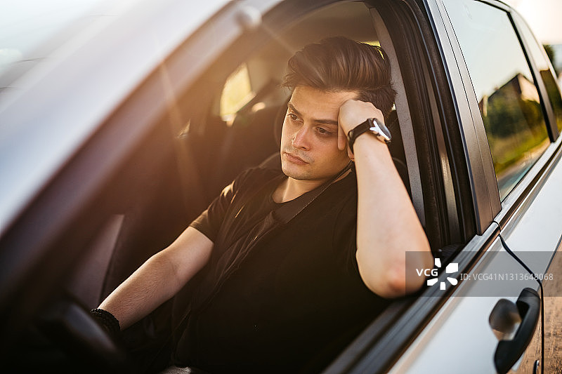 无聊的年轻人在车里等待图片素材