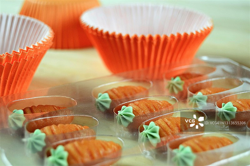 用小胡萝卜装饰的橙色纸杯蛋糕容器图片素材
