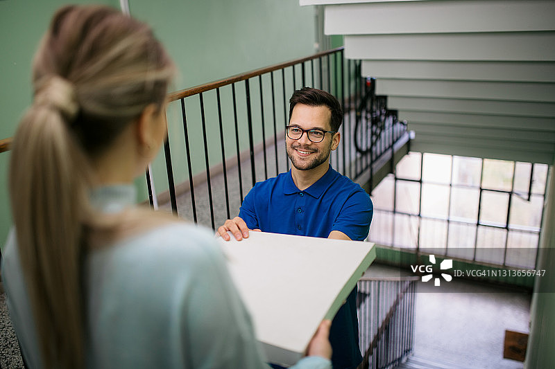 年轻白人披萨外卖员工作中的高角度视图图片素材