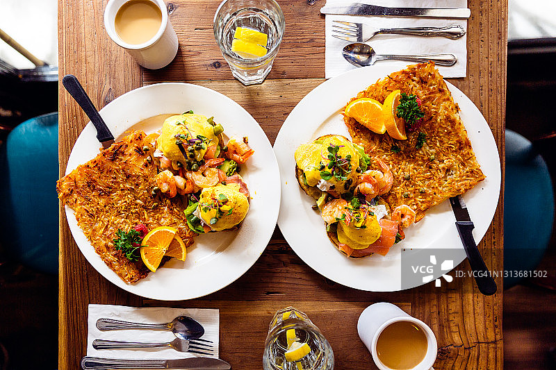 搭配三文鱼、虾和牛油果的班尼迪克蛋，配薯饼，高角度拍摄图片素材
