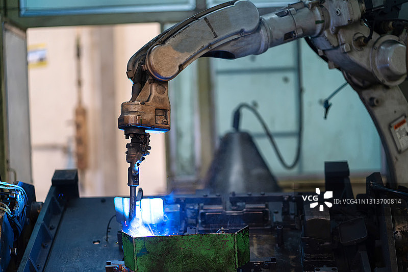 智能工厂工业中的机器人手臂机器正在监控系统软件。焊接机器人和数字化制造运营。图片素材