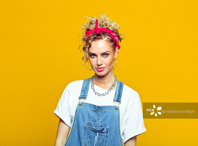身穿80年代风格服装的年轻女人，黄色背景上的肖像图片素材