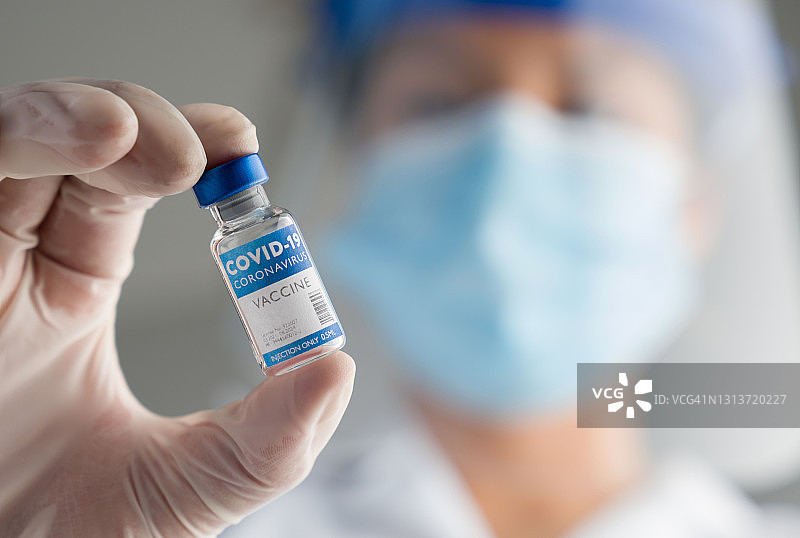 医护人员手持COVID-19疫苗安瓿图片素材