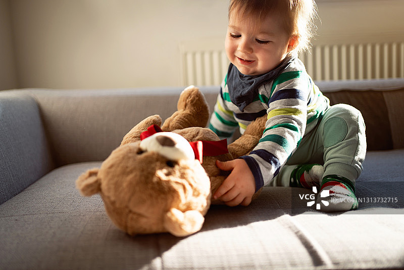 抱着泰迪熊的可爱男婴图片素材