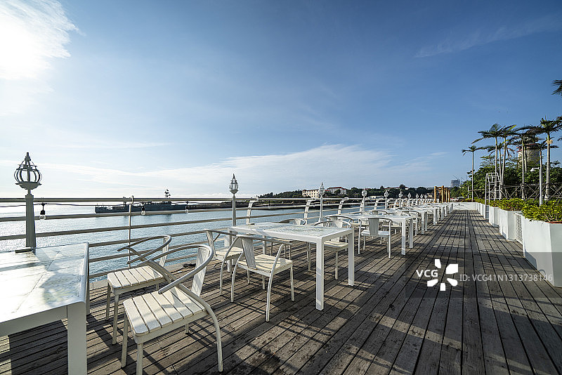 餐厅阳台上俯瞰海滩的空桌子图片素材