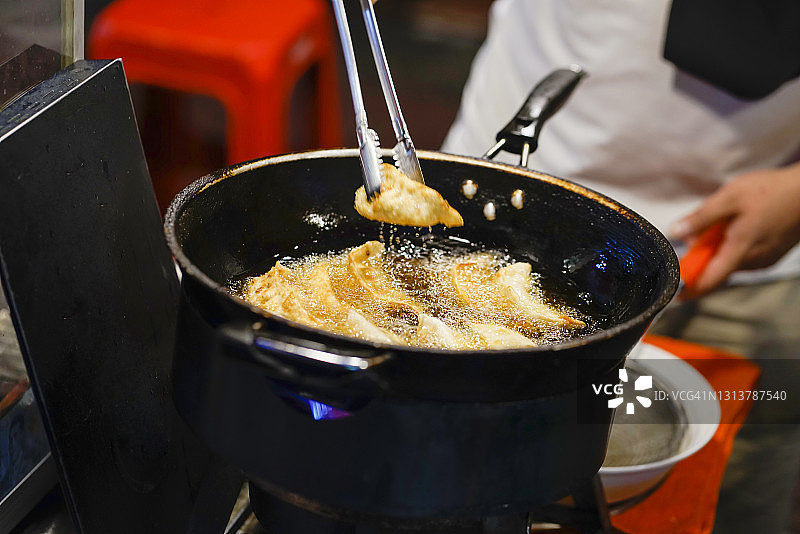 油锅中刚炸好的热气腾腾的饺子图片素材